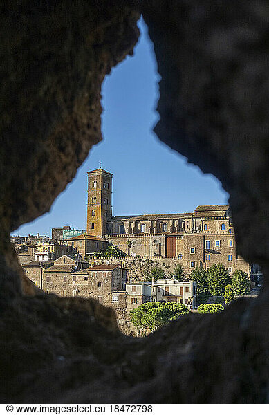 Italy  Lazio  Sutri  Cathedral of Santa Maria Assunta seen through hole in rock wall