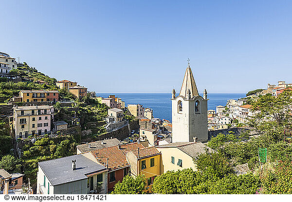Italy  Liguria  Riomaggiore  Houses of coastal town along Cinque Terre with church bell tower in foreground