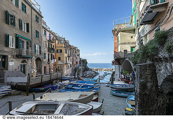 Italy  Liguria  Riomaggiore  Row of boats lying at edge of coastal town along Cinque Terre
