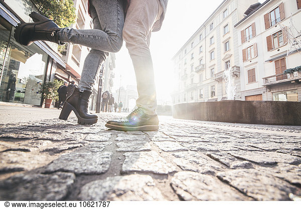 Italy Milan couple in love standing on cobblestone pavement