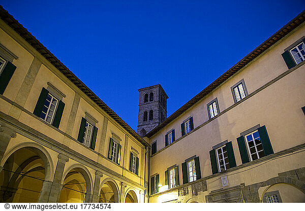 Italy  Province of Arezzo  Cortona  Shuttered windows at night with bell tower looming behind