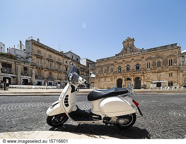 Italy  Province of Brindisi  Ostuni  White motor scooter parked in town square
