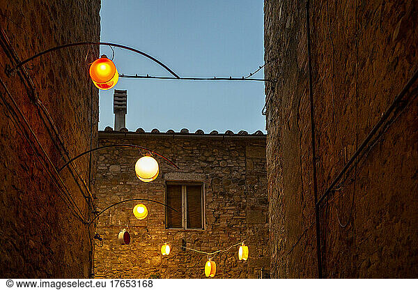 Italy  Province of Siena  Radicondoli  Lanterns illuminating old town alley