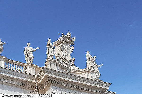 Italy  Rome  Low angle view of sculptures standing on top of colonnade of Saint Peters Square