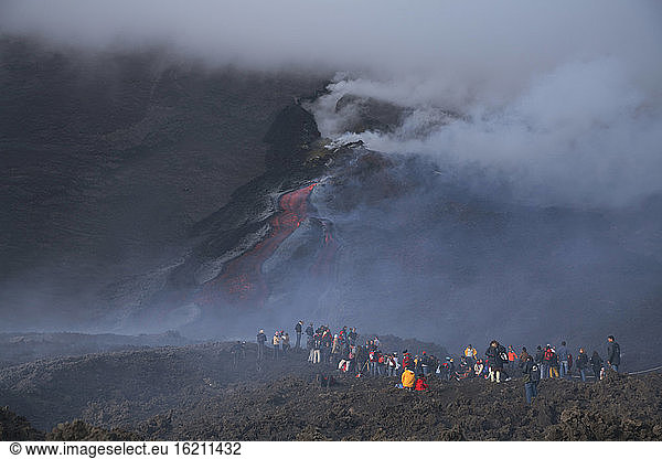 Italy  Sicily  Spectators watching lava flow at etna volcano