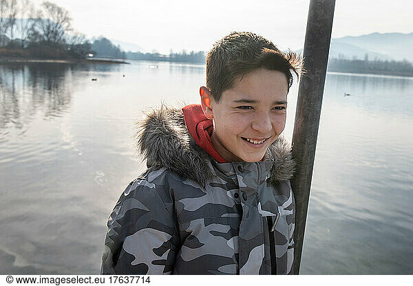 Italy  Smiling boy  by calm lake