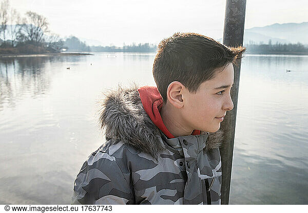 Italy  Smiling boy  by calm lake