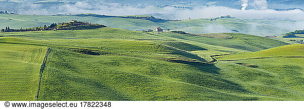 Italy  Tuscany  Volterra  Panoramic view of green rolling landscape on foggy morning