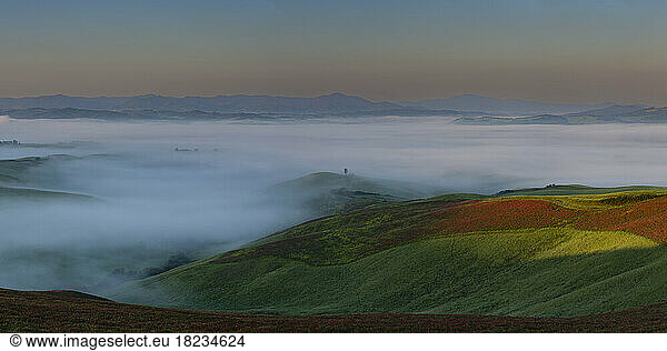 Italy  Tuscany  Volterra  Panoramic view of landscape shrouded in thick morning fog