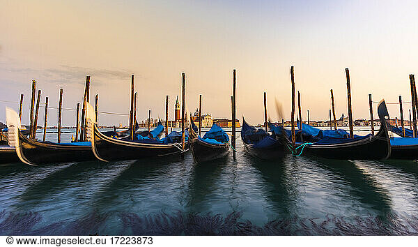 Italy  Veneto  Venice  Row of gondolas moored in marina at dusk