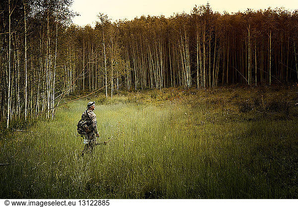 Jäger mit Pfeil und Bogen im Wald unterwegs