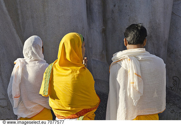Jain-Pilger rezitieren religiöse Texte zu F¸ßen der riesigen Statue des Gomateshwara in Sravanabelagola  Indien  Asien