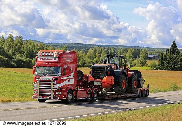 JAMSA  FINLAND - AUGUST 27  2018: Scania R580 truck of Sivenius Oy hauls Hitachi wheel loader on road through rural scenery on a beautiful day of summer.