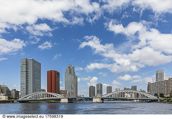 Japan  Kanto Region  Tokyo  Clouds over waterfront skyscrapers with Kachidoki Bridge in foreground