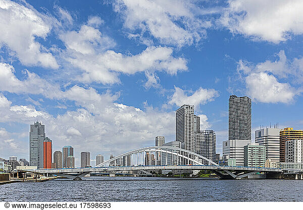 Japan  Kanto Region  Tokyo  Clouds over waterfront skyscrapers with Tsukiji Great Bridge in foreground