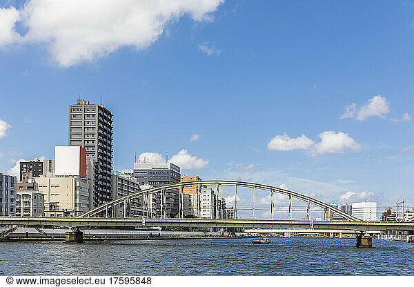 Japan  Kanto Region  Tokyo  Railway bridge stretching over Sumida River with apartment buildings in background
