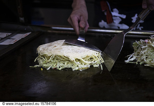 Japan  Kyoto  Close-up of chef preparing Okonomiyaki in restaurant