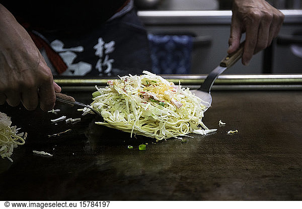 Japan  Kyoto  Close-up of chef preparing Okonomiyaki in restaurant