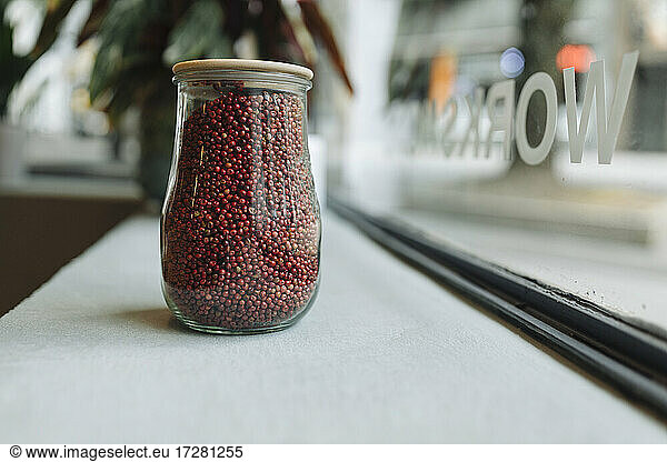 Jar full of grain on window sill in cafe