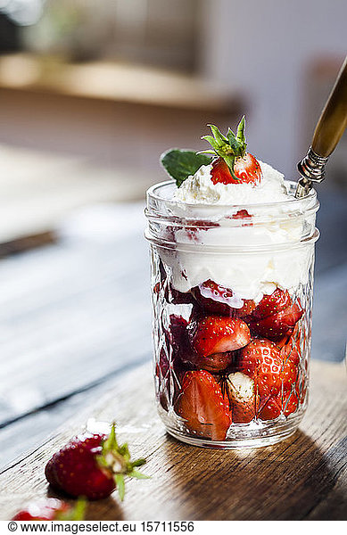 Jar of fresh strawberries with whipped cream