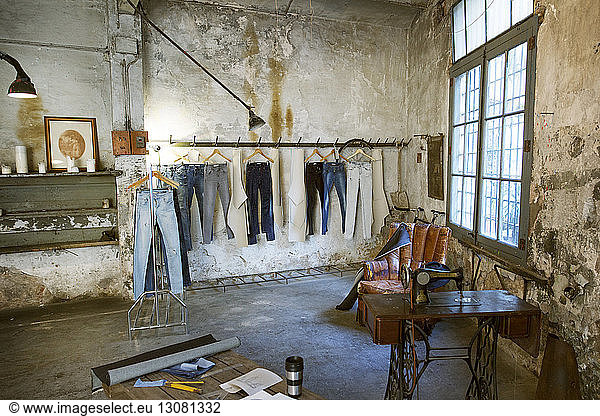 Jeans hängen auf einem Gestell in alter Werkstatt