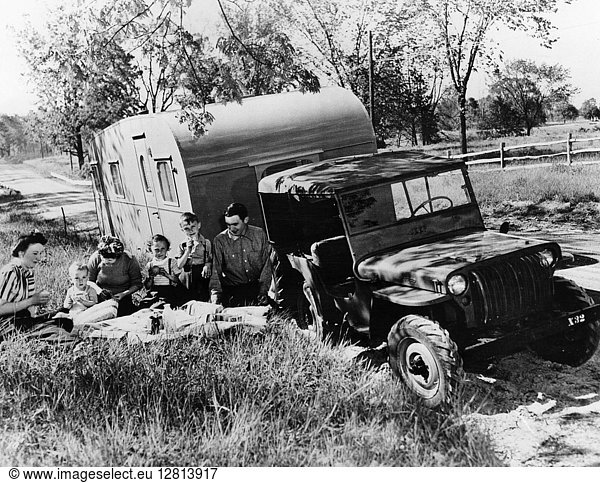 JEEP AND TRAILER  1945. An American family picnicking on the side of a road in front of their trailer  which is hitched to a Willys-Overland postwar Jeep. Photographed in 1945.