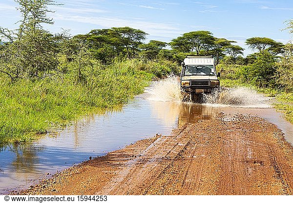 Jeep durchquert eine Furt mit Wasser Serengeti Nationalpark Tansania Afrika