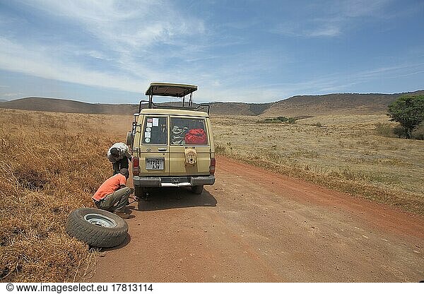 Jeep with spare wheel changing tyre due to car breakdown in Ngorongoro Crater  Serengeti  Tanzania  Africa