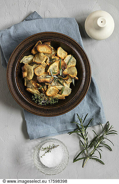 Jerusalem Artichoke chips garnished with rosemary in bowl