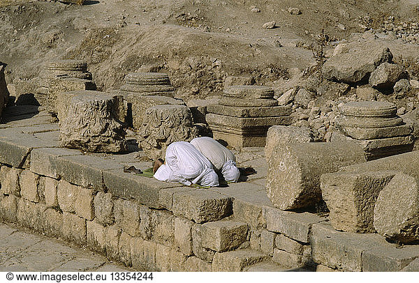 JORDAN Jerash Two muslim men pray towrds Mecca.