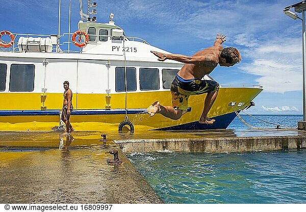 Jugendliche  die neben dem Hafen von Bora Bora Vaitape ins Wasser springen  Gesellschaftsinseln  Französisch-Polynesien  Südpazifik.