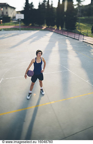 Jugendlicher Basketballspieler mit Ball auf dem Spielfeld