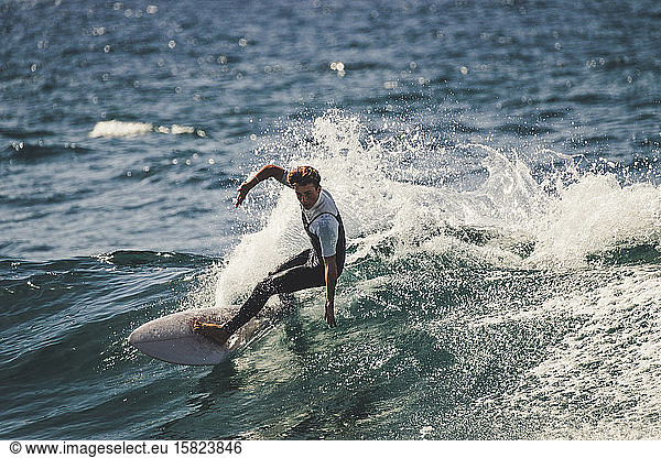 Jugendlicher surft im Meer