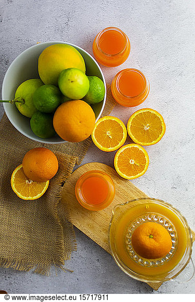 Juicer  ripe citrus fruits and jars of freshly squeezed orange juice