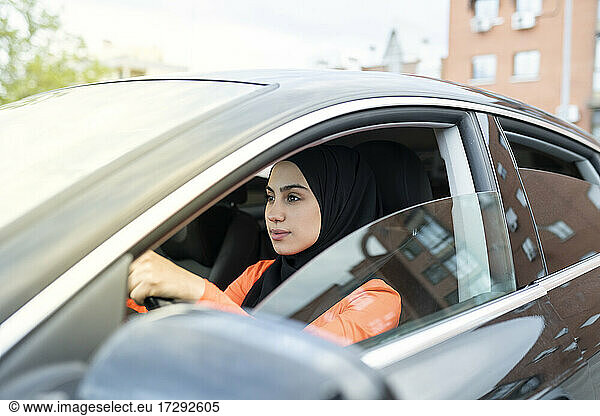 Junge arabische Frau fährt Auto im Freien
