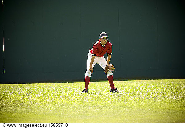 Junge auf bereiter Position im Aussenfeld eines Baseballfeldes