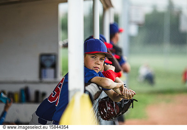 Junge auf der Spielerbank während eines Baseball-Spiels der kleinen Liga
