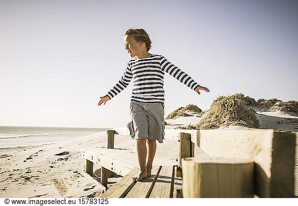 Junge balanciert auf der Strandpromenade
