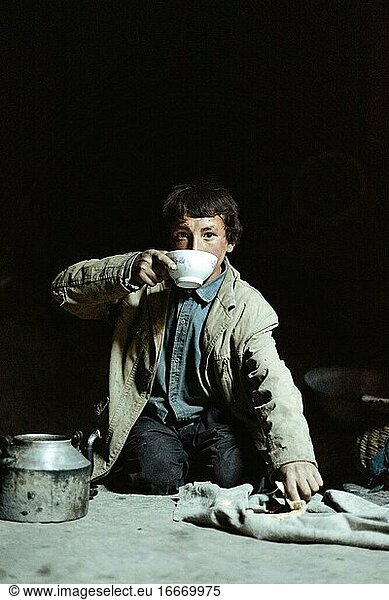 Junge bei der Mahlzeit  er taucht hartes Fladenbrot in Milch  Wakhi  Saradh-e-Broghil  Afghanistan  Asien
