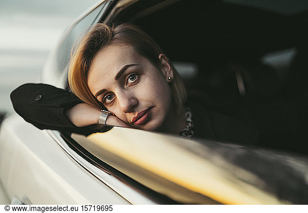 Junge blonde Frau schaut aus dem Autofenster
