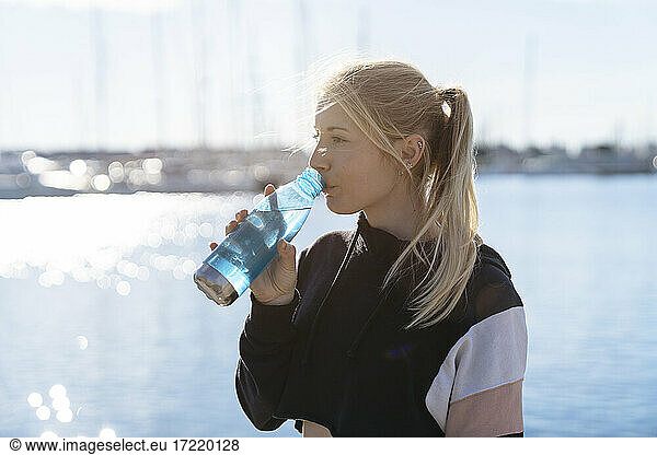 Junge blonde Frau trinkt Wasser