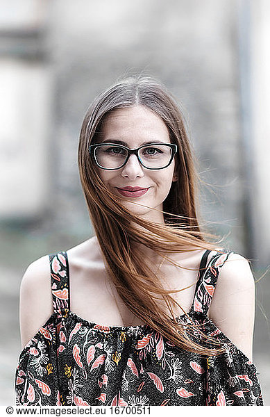 junge braunhaarige Millennials mit Brille und hellem Kleid