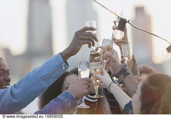 Junge erwachsene Freunde toasten Champagnerflöten auf der Party