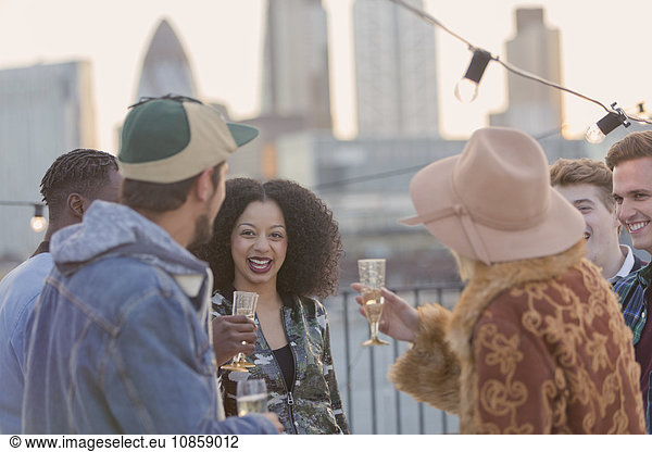 Junge erwachsene Freunde trinken Champagner auf der Dachparty