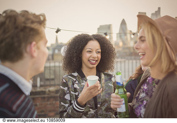Junge erwachsene Freunde trinken und genießen Dachparty