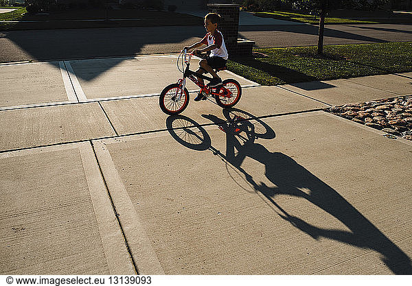 Junge fährt Fahrrad auf Bürgersteig