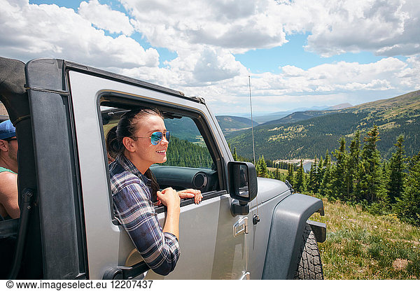 Junge Frau auf Autoreise mit Blick vom geparkten Geländewagen  Breckenridge  Colorado  USA