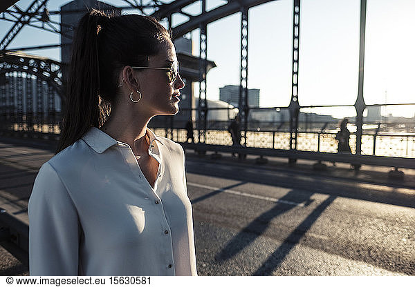 Junge Frau auf einer Brücke im Abendlicht