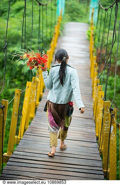 Junge Frau auf Fußgängerbrücke mit Blumen  Shan-Staat  Keng Tung  Burma
