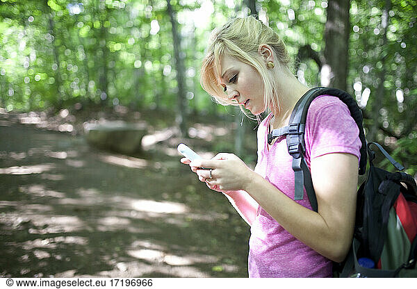 Junge Frau beim Wandern mit Technik